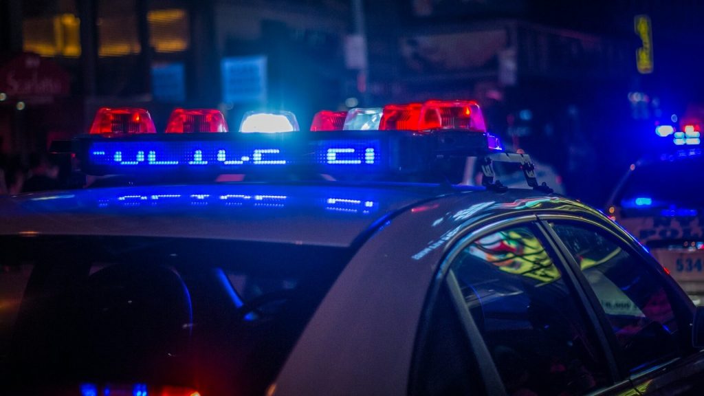 Un coche de policía de noche con las luces encendidas 